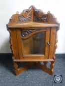 A small carved walnut glazed hanging corner cabinet