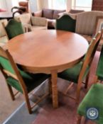 A circular oak dining table and six oak dining chairs