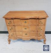 A continental oak serpentine front chest of three drawers