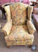 An early 20th century mahogany framed wingback armchair in floral upholstery
