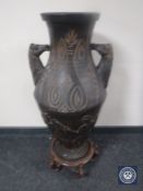 A large pottery vase with horse head handles,