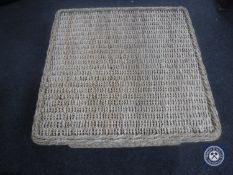 A wicker and glass top coffee table