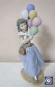 A Lladro figure of a girl holding balloons,