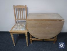 A pine drop leaf table and a pine chair