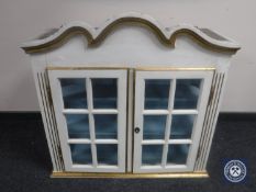 A white and gilt glazed wall cabinet