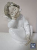 A Lladro figure of a seated angel,