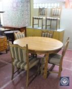 A blonde oak circular table and six dining chairs