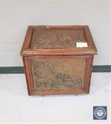 A 19th century oak coal receiver with embossed copper panels depicting traditional scenes