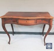 A late 19th century rosewood serpentine front console table fitted three drawers