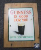 A Guinness advertisement on pine board