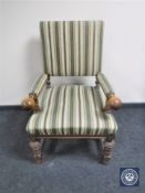 A carved oak armchair in striped upholstery
