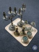 A tray containing a pair of three-branch brass candelabra and three other pairs of brass