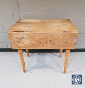 An antique pine drop leaf kitchen table