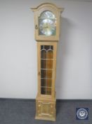 A blond oak Tempus Fugit longcase clock with pendulum and weights