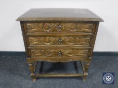 A continental carved oak low chest of three drawers