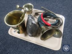 A tray of two brass horns, cowbell,