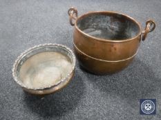 A twin handled copper cooking pot and another copper dish