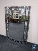 A contemporary all glass mirror with pierced frame