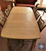A blonde oak extending table with leaf and six matching dining chairs