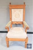 A blond oak framed armchair with tapestry back rest