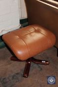 A tan leather footstool on rosewood effect base