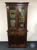 A Victorian mahogany glazed door bookcase with sign writer's advertisement