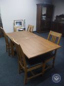 A contemporary oak turnover top dining table together with four chairs