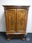 An antique continental mahogany double door cabinet with walnut panel doors