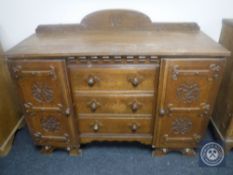 An early 20th century carved oak Arts & Crafts sideboard