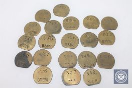 Twenty vintage brass railway pay check tokens.