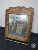 A carved oak mirrored door cabinet