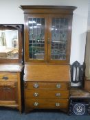 An Edwardian oak Arts & Crafts bureau bookcase with leaded glass doors