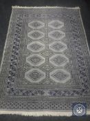 An Afghan design rug on blue-grey ground,