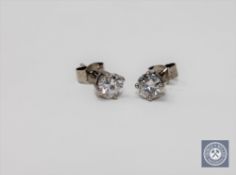 A pair of solitaire diamond stud earrings, the total diamond weight estimated at 0.