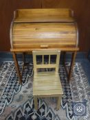 A child's roll top desk with chair