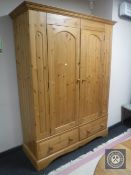 A pine double door wardrobe fitted two drawers