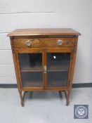 An Edwardian oak double door cabinet fitted a drawer