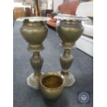 Two brass jardiniere stands together with a brass planter