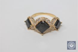 A 14ct yellow gold trilogy halo black and white diamond ring featuring 3 black diamonds 4.
