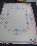 A fringed woolen carpet on pink ground