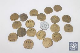 Twenty vintage brass railway pay check tokens.