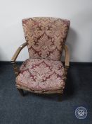 A mid 20th century bedroom chair upholstered in a red and gold classical buttoned fabric