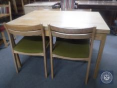 A mid 20th century pull out dining table together with four chairs