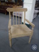 An antique pine kitchen armchair