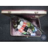 A mid 20th century luggage case containing brass hand bell, cufflinks, Casio hand held TV,