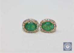 A pair of 14ct yellow gold emerald and diamond earrings, featuring 2 oval cut emeralds 2.