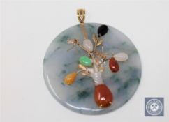 A large jade disc pendant set with various coloured jade mounted in gold