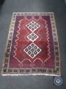An Afshar rug, South West Iran, the three stepped ivory medallions upon a red field,
