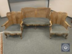 An Edwardian three piece walnut bergere lounge suite comprising two seater settee and pair of