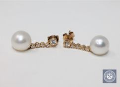 A pair of 14ct yellow gold white pearl and diamond earrings, featuring two white pearls,